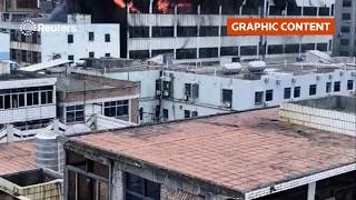 WARNING: DISTRESSING CONTENT: People seen on rooftop as fire rips through China shoe factory